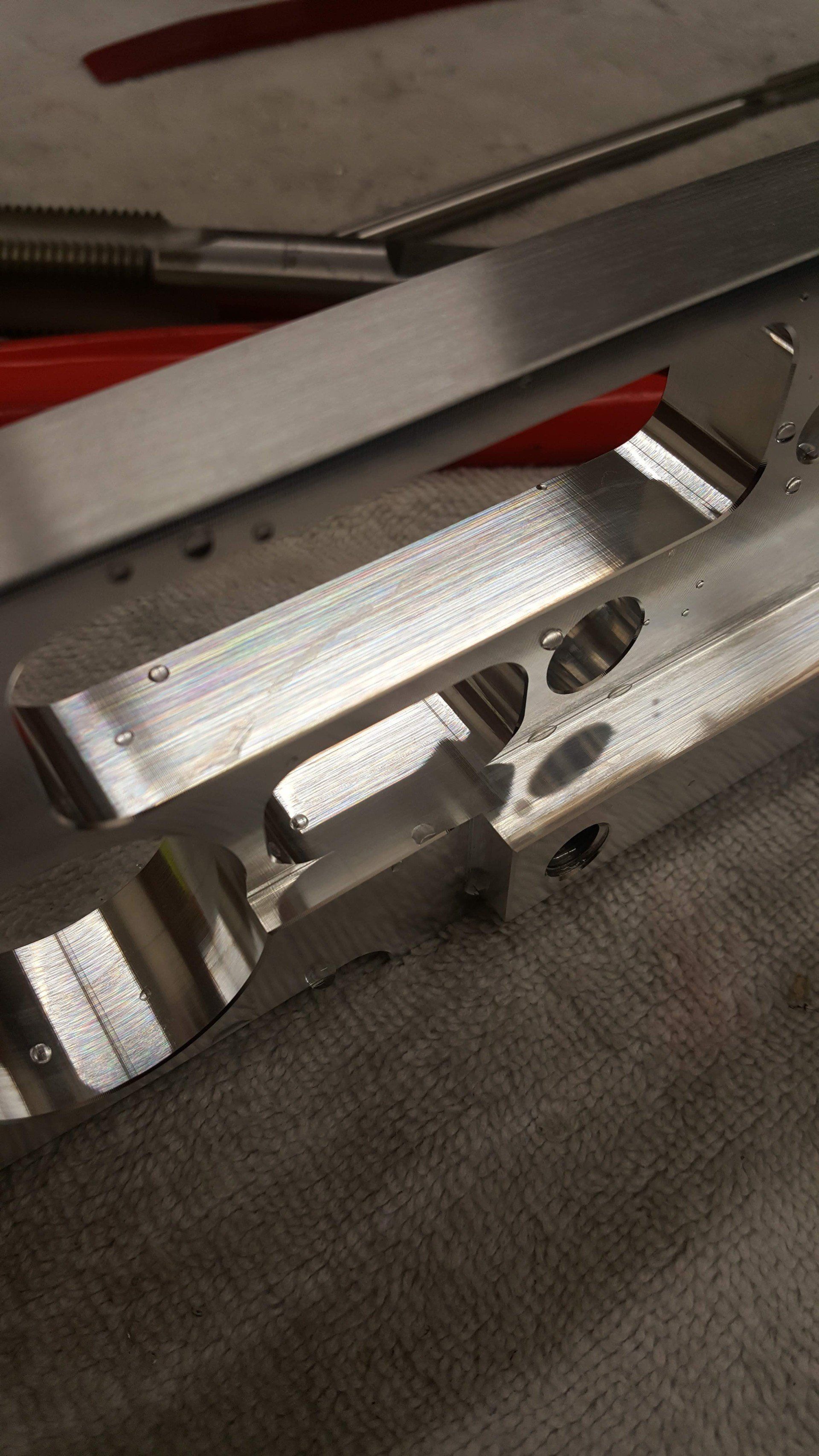 A piece of metal is sitting on a table next to a pair of pliers.