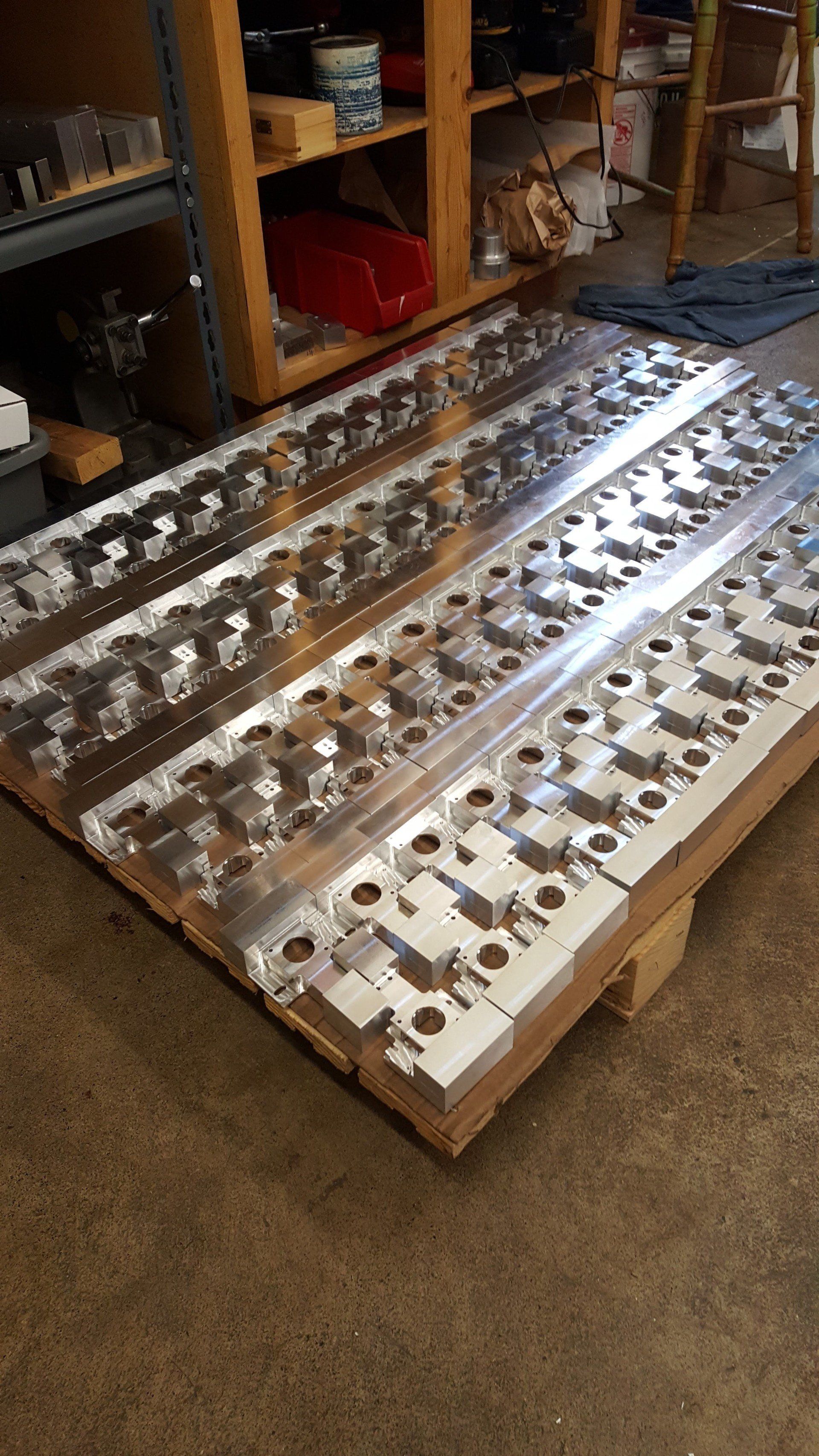 A bunch of metal pieces are sitting on top of a wooden pallet.