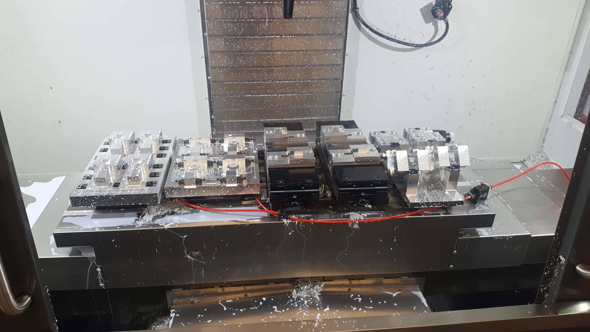 A machine is cutting a piece of metal on a table.