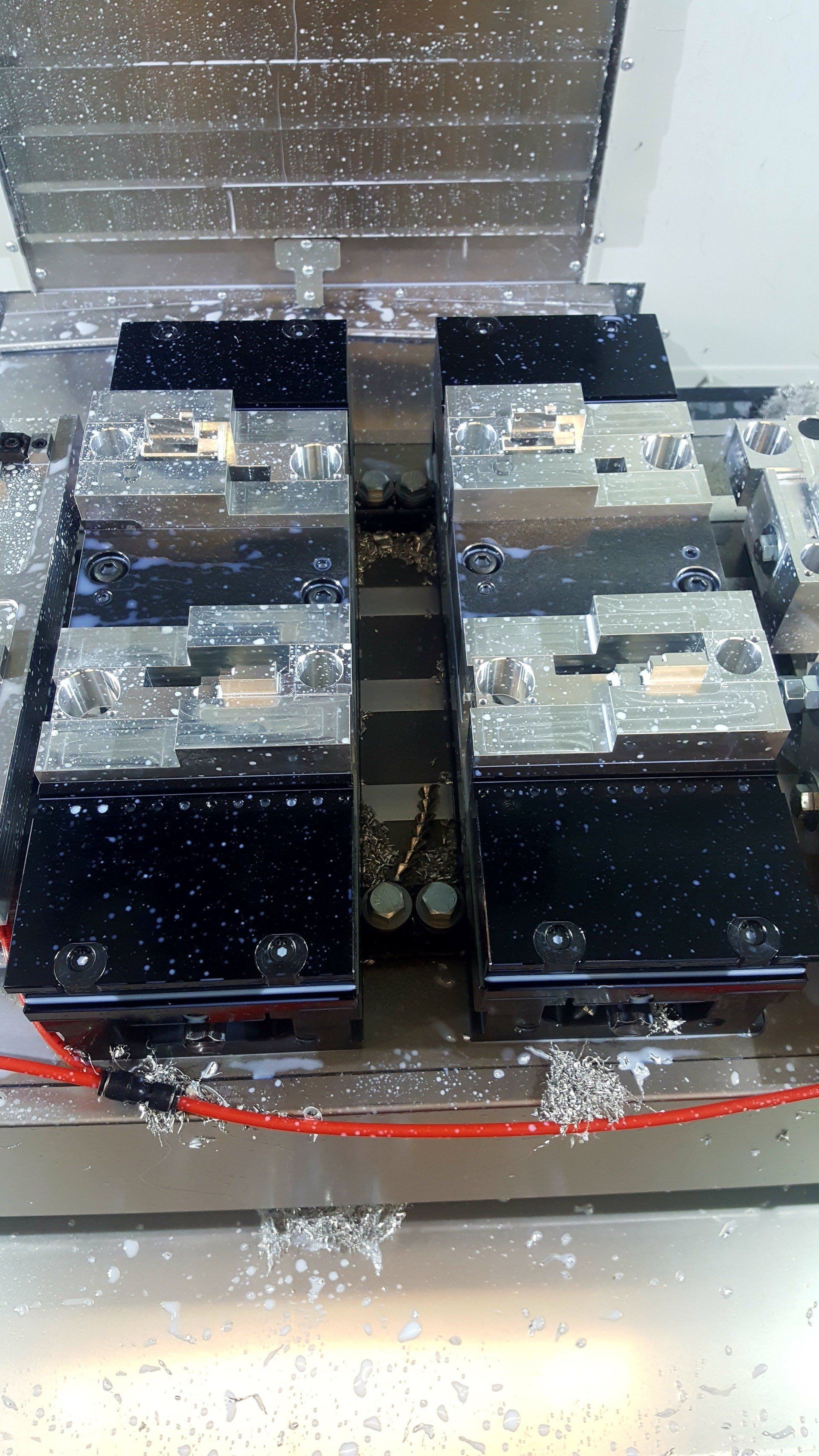 A machine is cutting a piece of metal on a table.