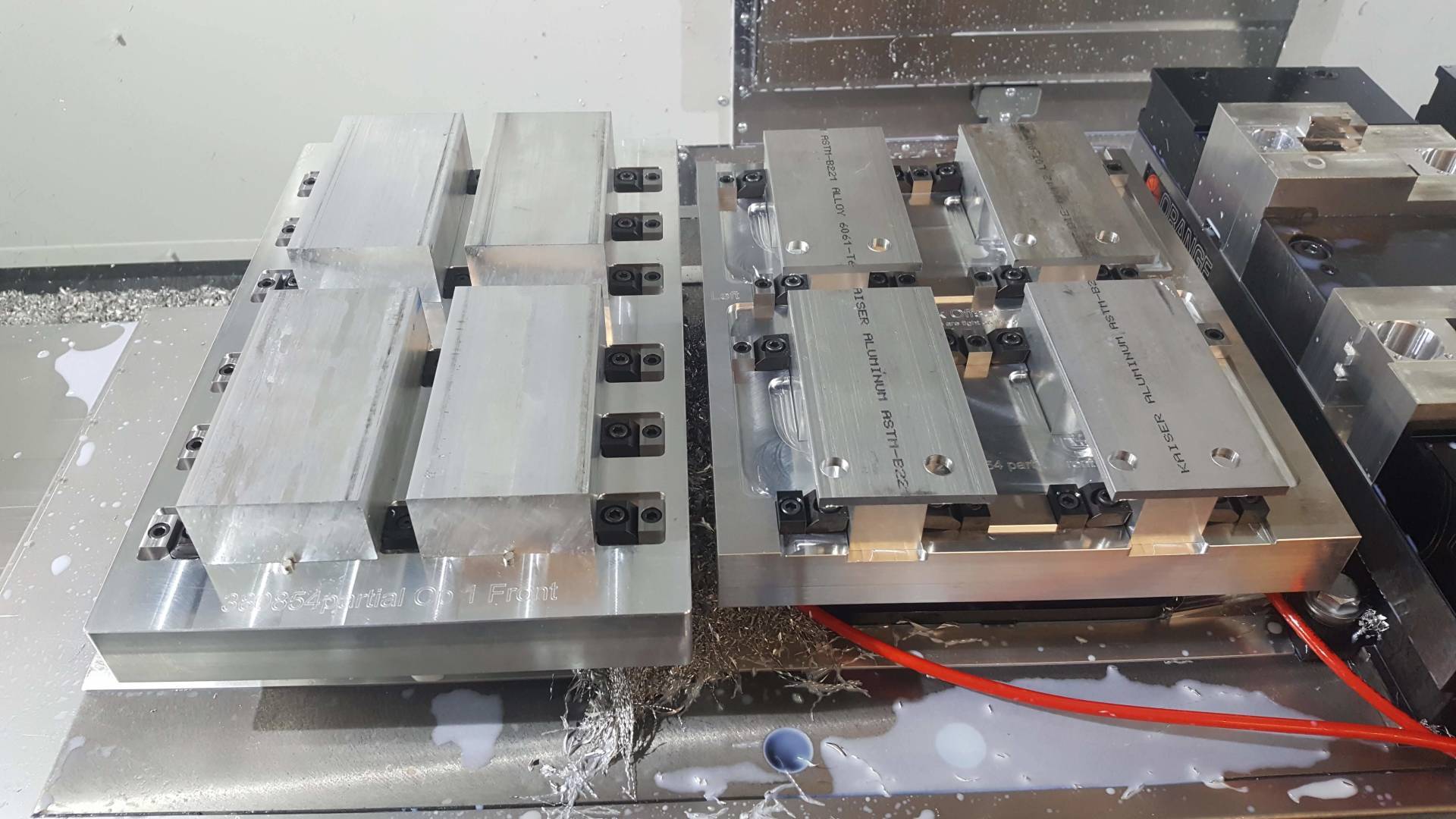 A machine is cutting a piece of metal on a table