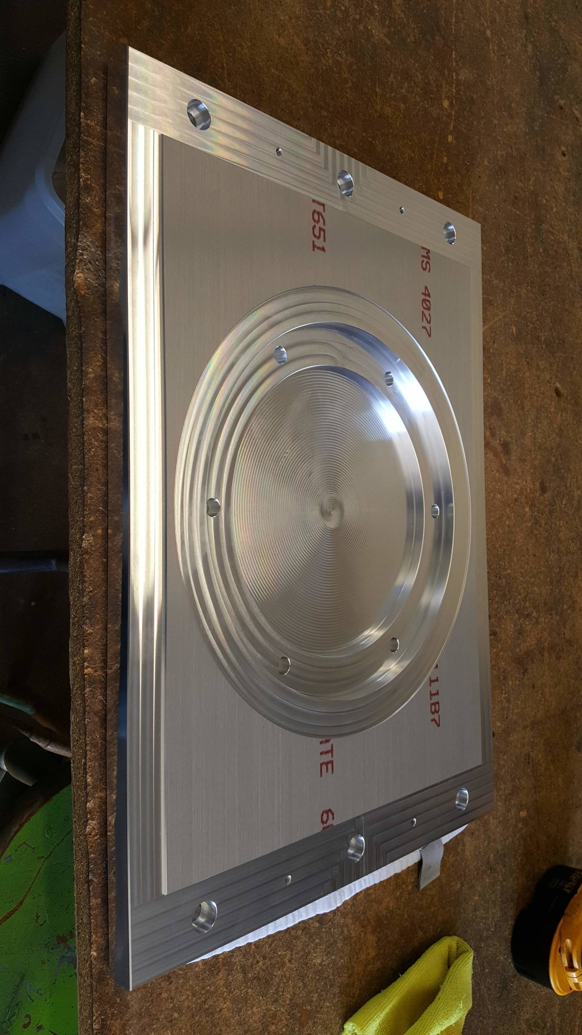 A piece of metal is sitting on top of a wooden table.