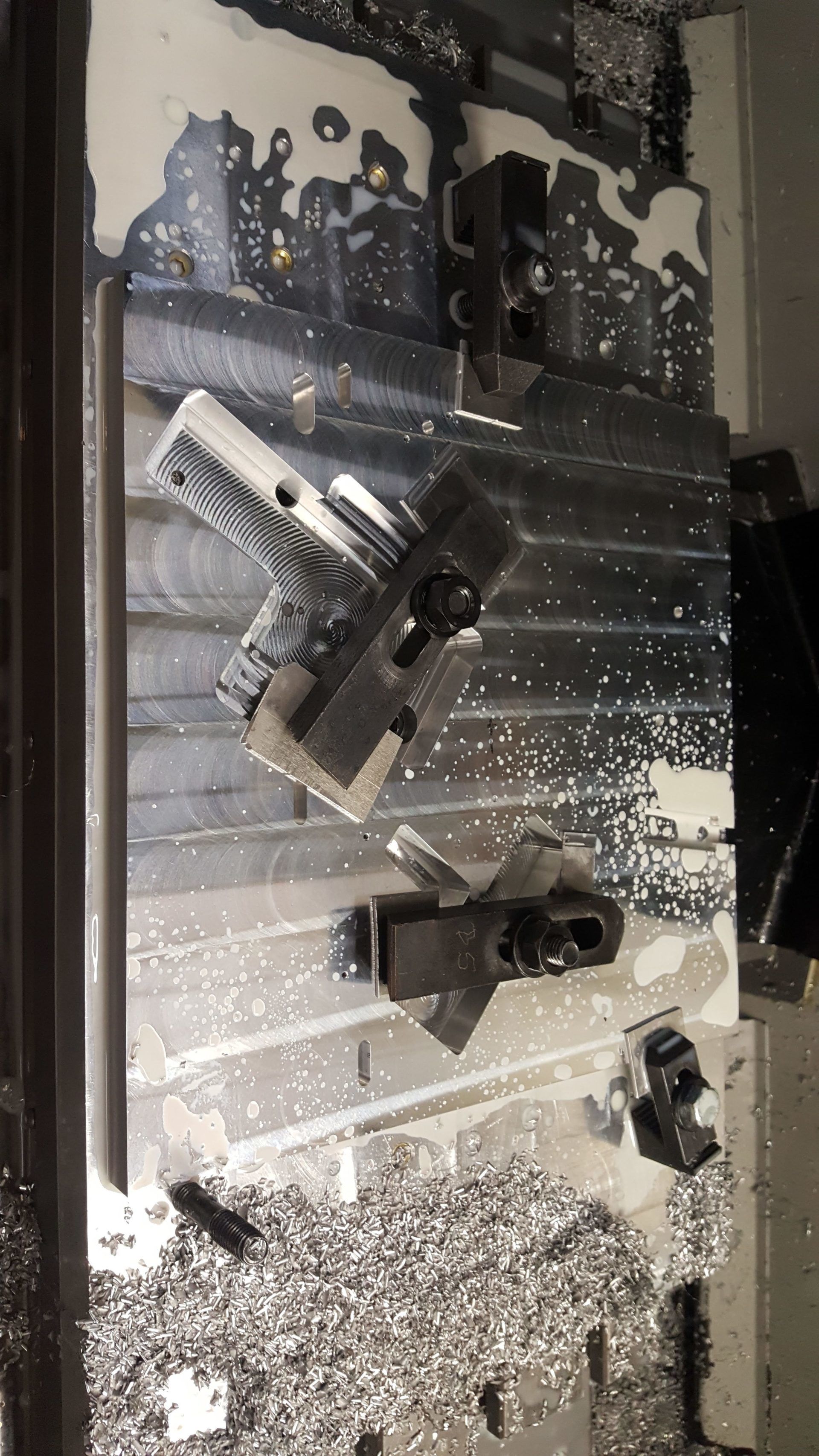 A black and white photo of a machine cutting a piece of metal.