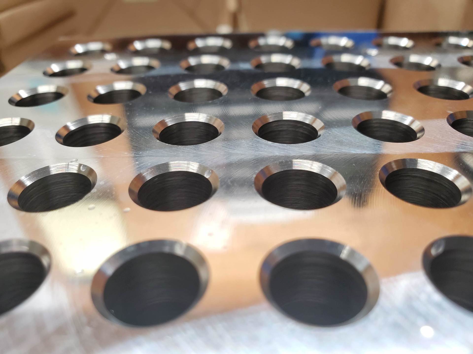 A close up of a metal tray with holes in it.
