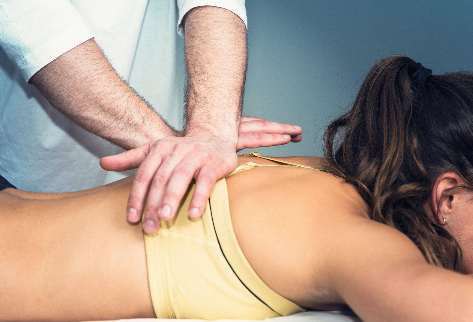 A woman is laying on a table getting a massage from a man.
