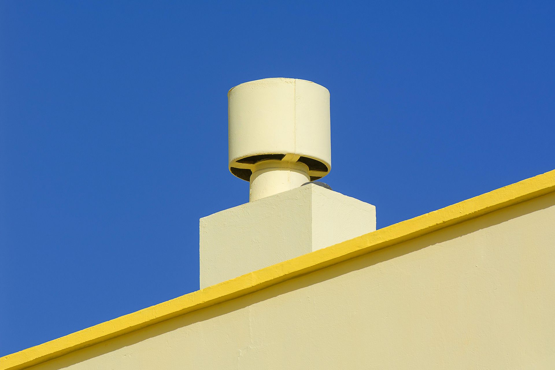 A large metal pipe is attached to the side of a building.
