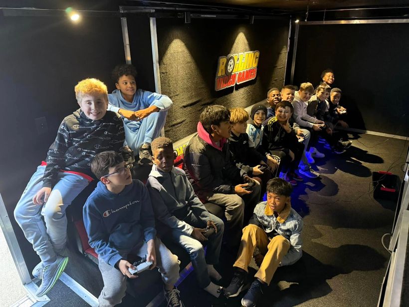 A group of young people are sitting in a room playing video games.