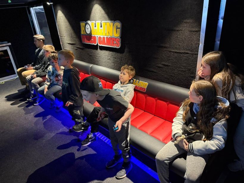 A group of children are sitting on a couch playing a video game.
