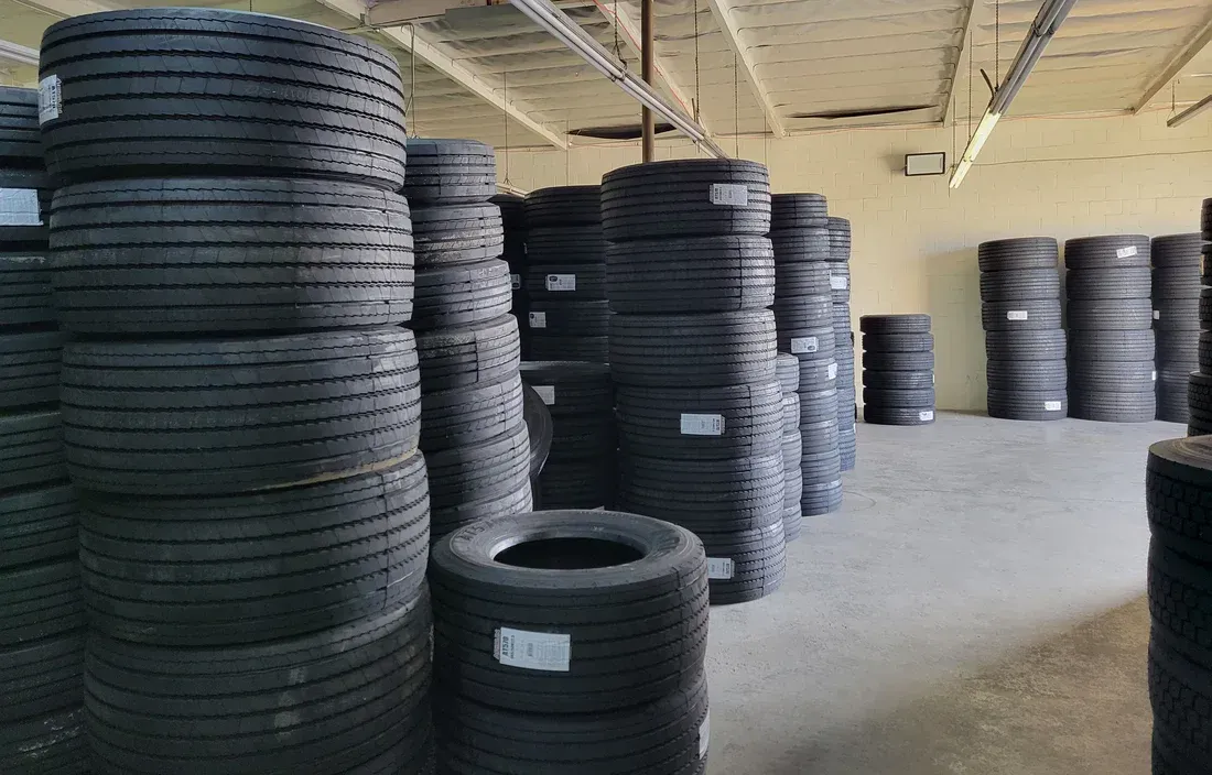 Stacks of black tires inside a warehouse.