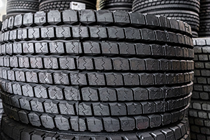 A selection of black semi-truck tires with a tread pattern, ready for use.