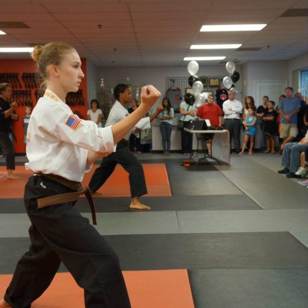 A group of men are practicing karate in a gym.