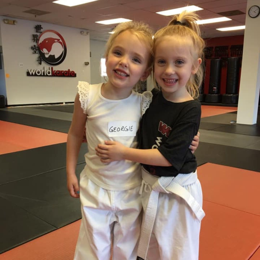 A boy and a girl are practicing taekwondo together.