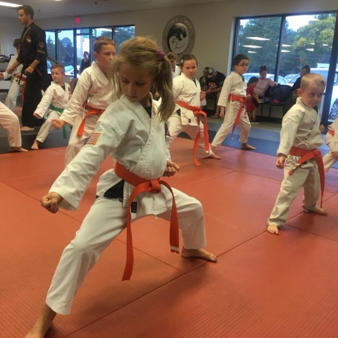 A boy and a girl are practicing taekwondo together.