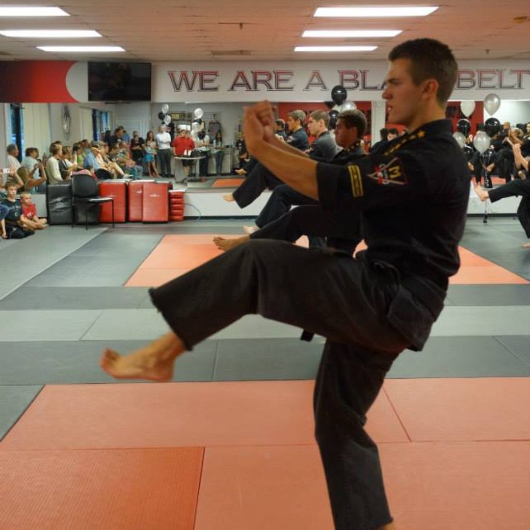 A group of men are practicing karate in a gym.