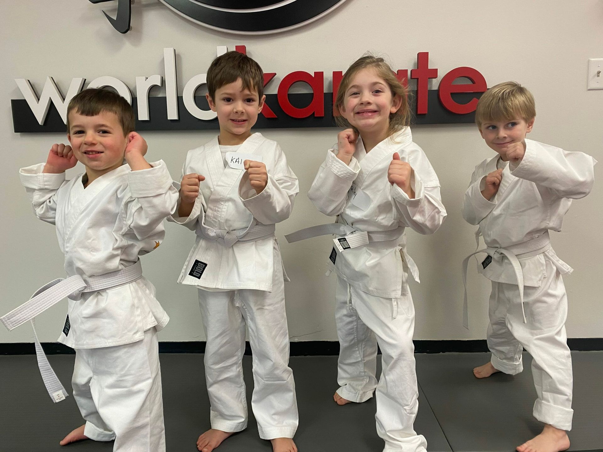 A group of young girls are practicing karate in a gym.