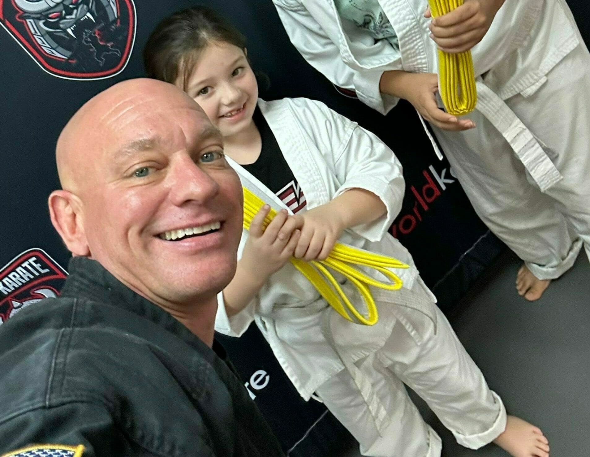 A man and a woman are practicing karate in a gym.