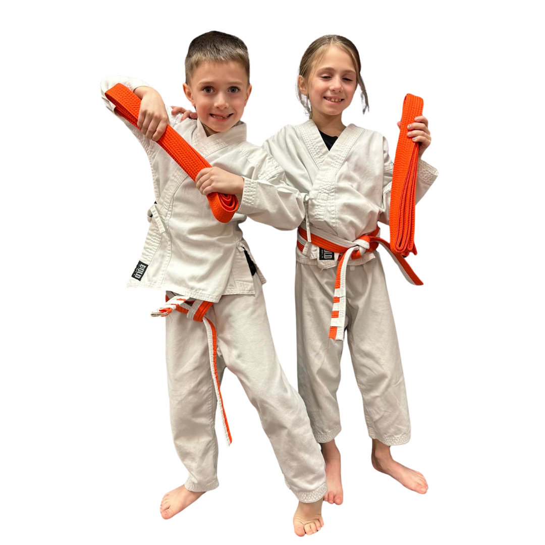 A boy and two girls are wearing karate uniforms and pointing at the camera