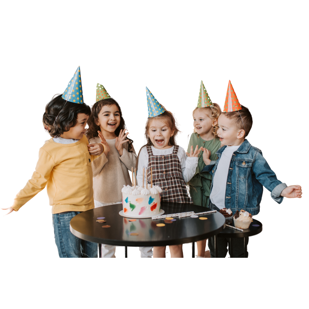 A boy wearing a party hat is laying on the floor with balloons and giving a thumbs up