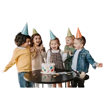 A boy wearing a party hat is laying on the floor with balloons and giving a thumbs up