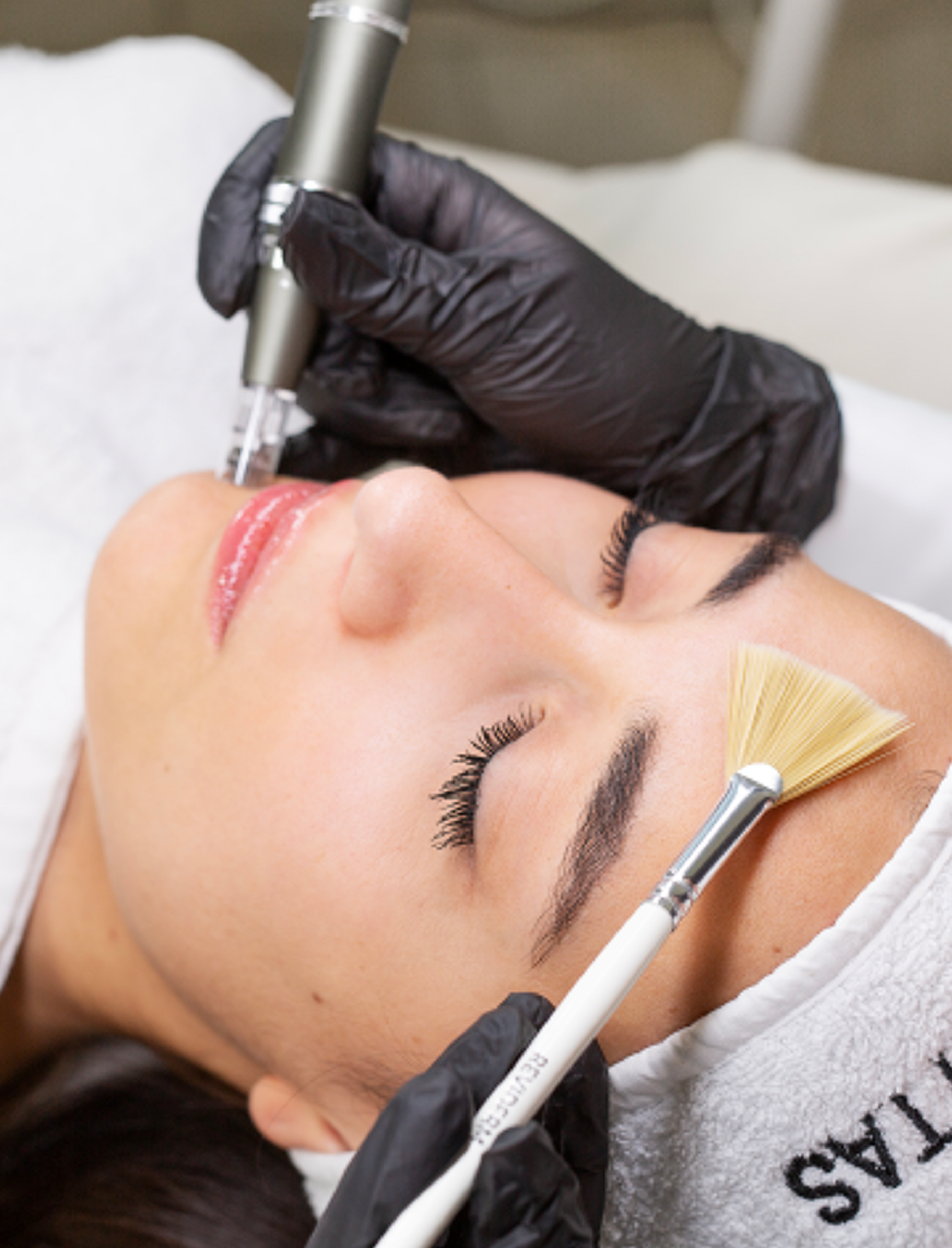 Eine Frau bekommt eine Gesichtsbehandlung mit einer Bürste