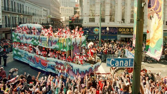 Mardi Gras parade float on Canal Street, New Orleans; people wave.
