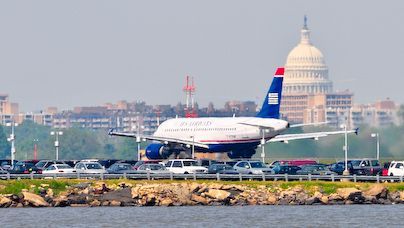 An airliner on the runway, Washington D.C. Capitol building in the background.