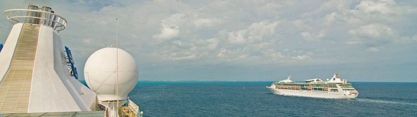 A cruise ship sailing on a blue ocean, another cruise ship in the distance. Cloudy sky.