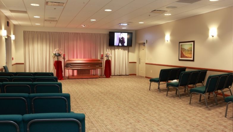 an empty auditorium with rows of seats and a coffin in the background .