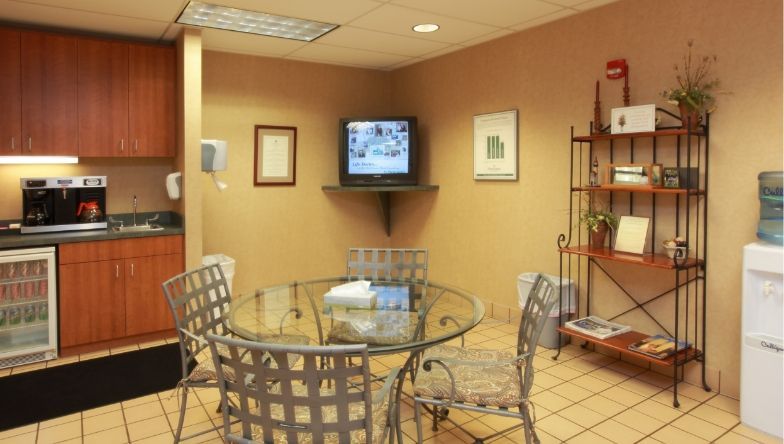 a room with tables and chairs and a picture on the wall .