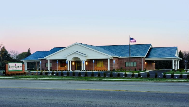 A brick building with a blue roof and a sign that says funeral home