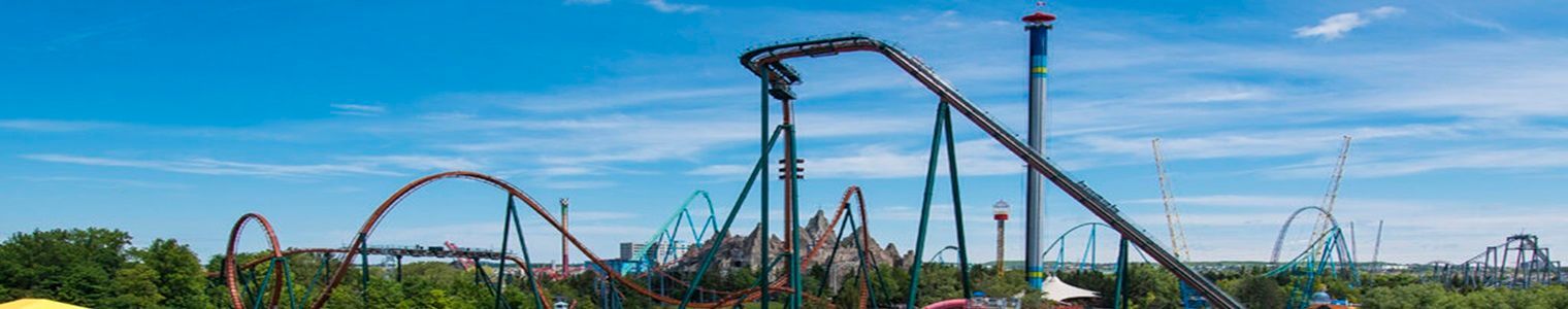 A roller coaster at an amusement park with a blue sky in the background.