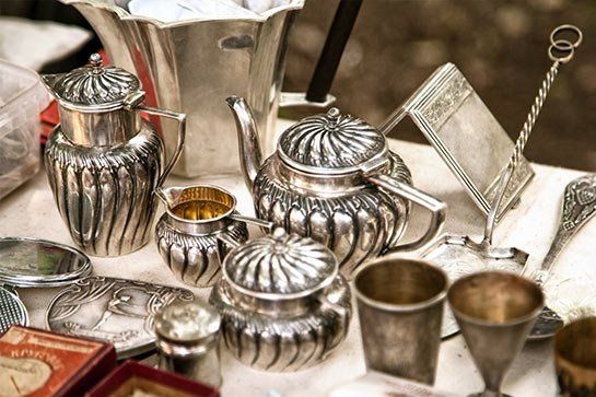 A table topped with a variety of silver objects.