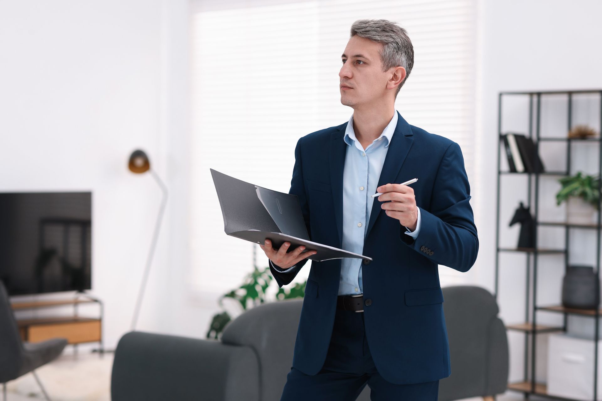 Inspector with folder conducting property valuation at home.