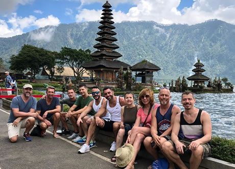 Colorful rainbow crosswalk in Cape Town's colorful Bo-Kaap neighborhood, with pedestrians and a modern building.