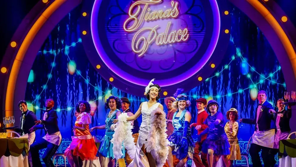 Musical performance, stage set. Performers in colorful costumes, dancing. 