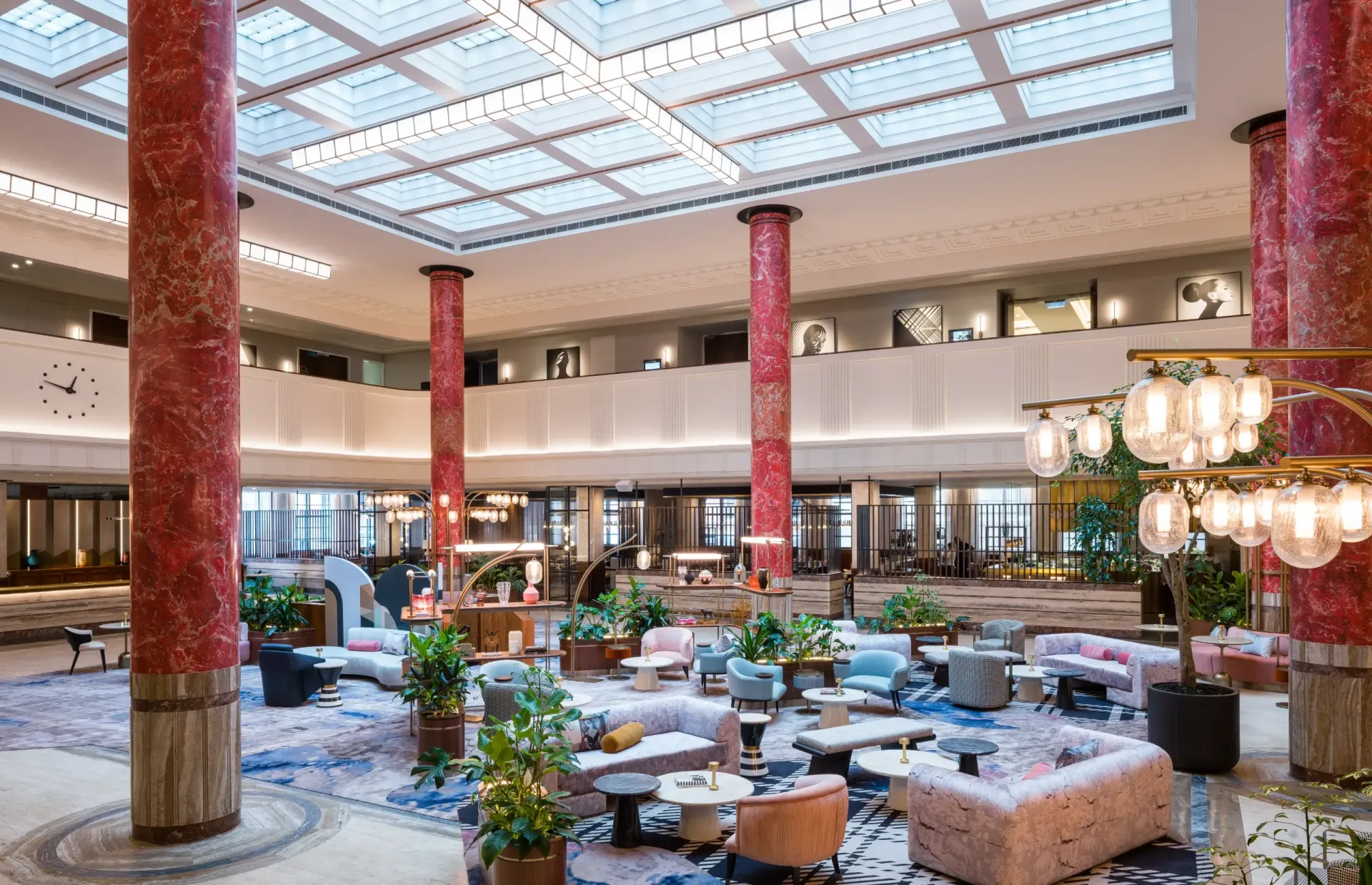 Grand hotel lobby with red marble columns, seating areas, and a glass ceiling. Kimpton Margot Sydney