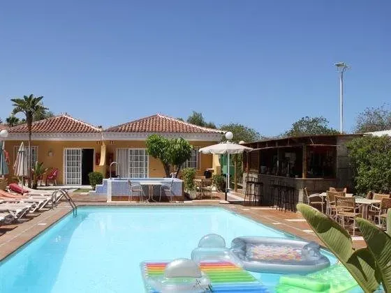 A large swimming pool with a house in the background