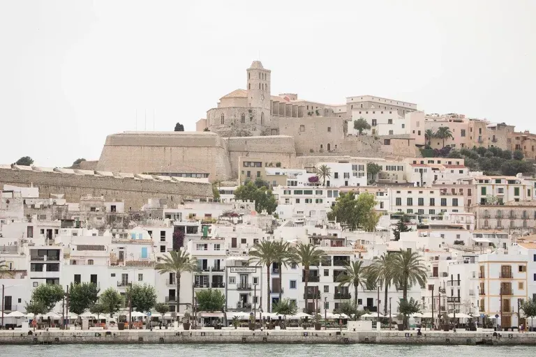 A city sitting on top of a hill next to a body of water.