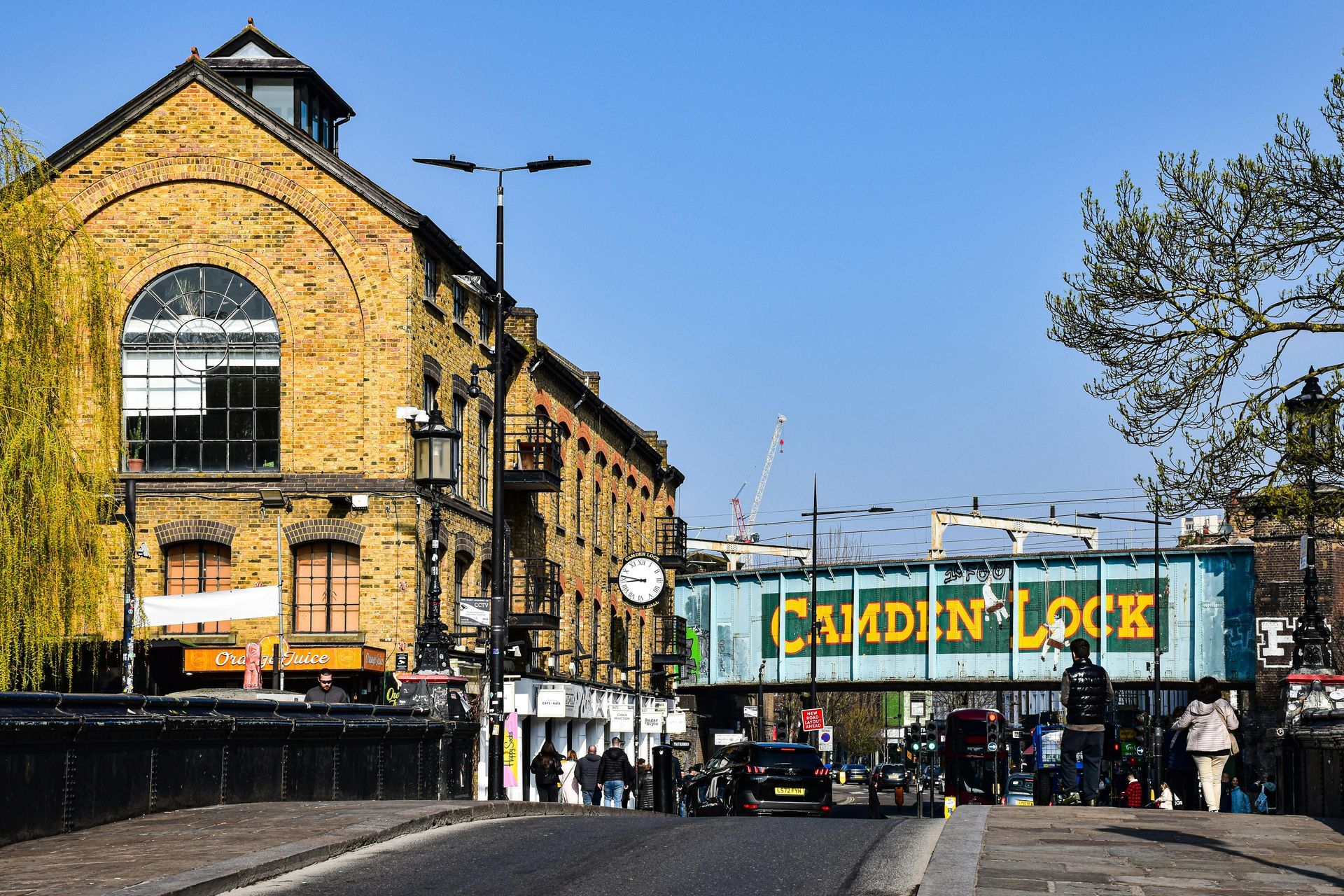 Camden Lock, London: Brick buildings line street, bridge says