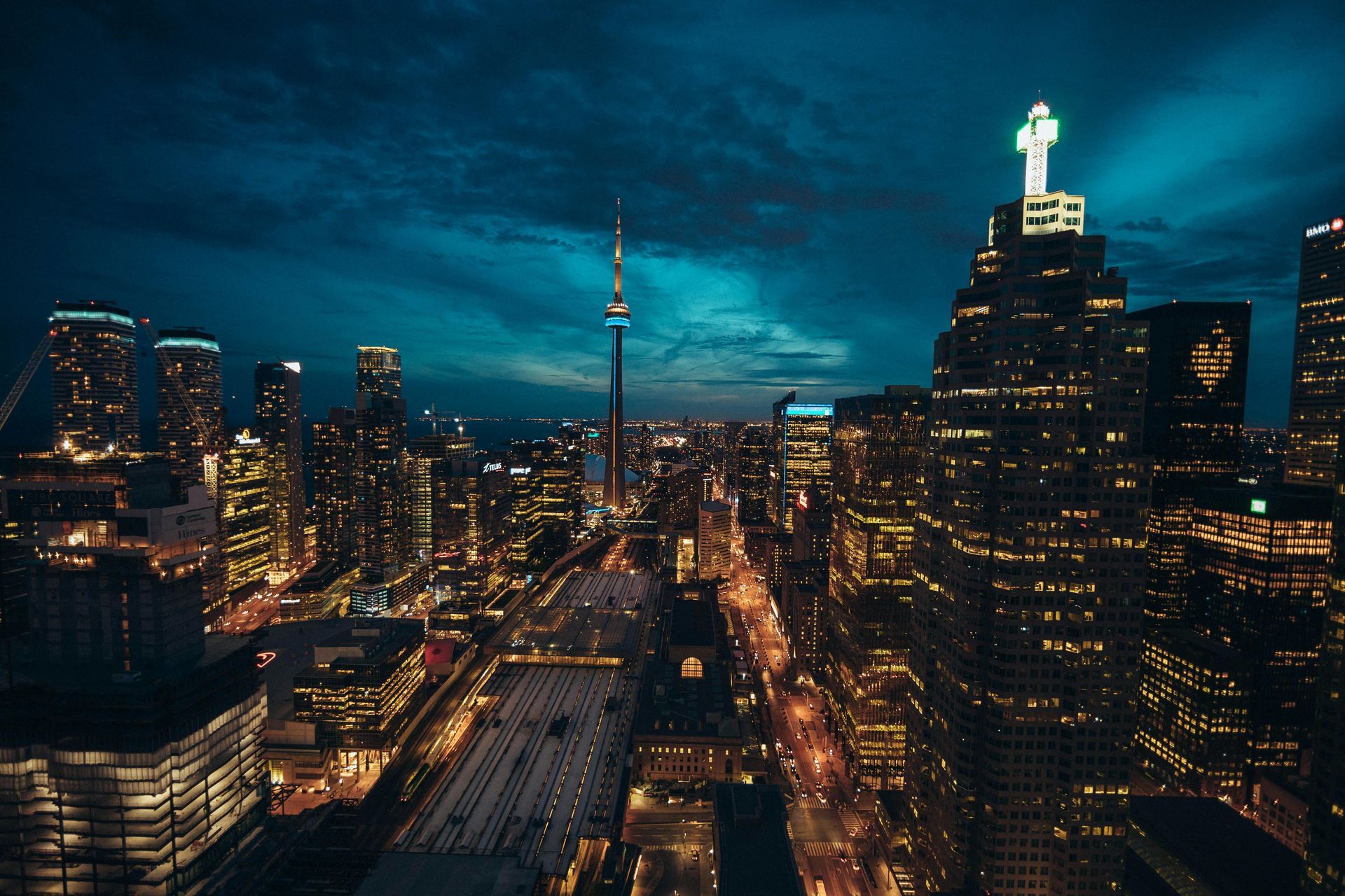Night view of Toronto skyline with lit skyscrapers and CN Tower.