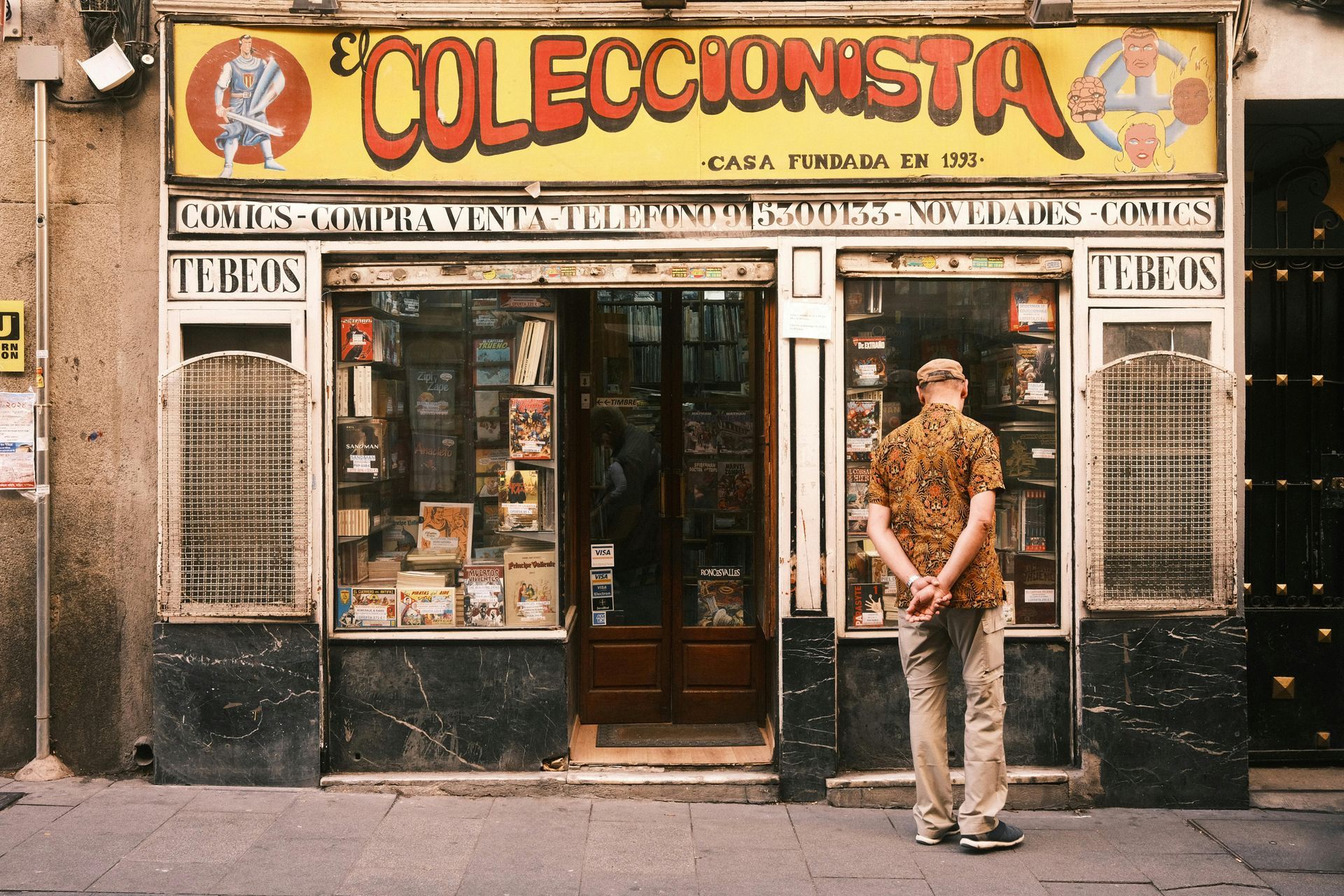 Man standing outside a comic book store,