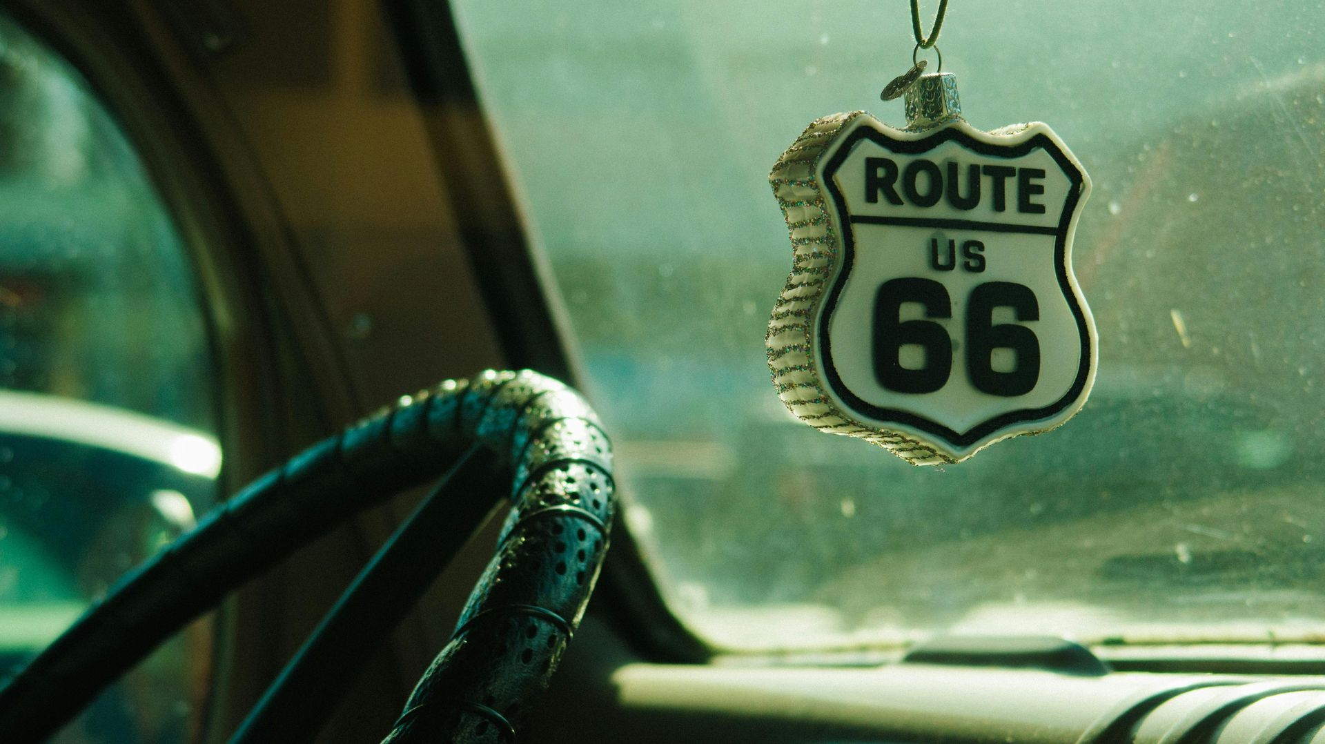 Steering wheel and Route 66 ornament in car.