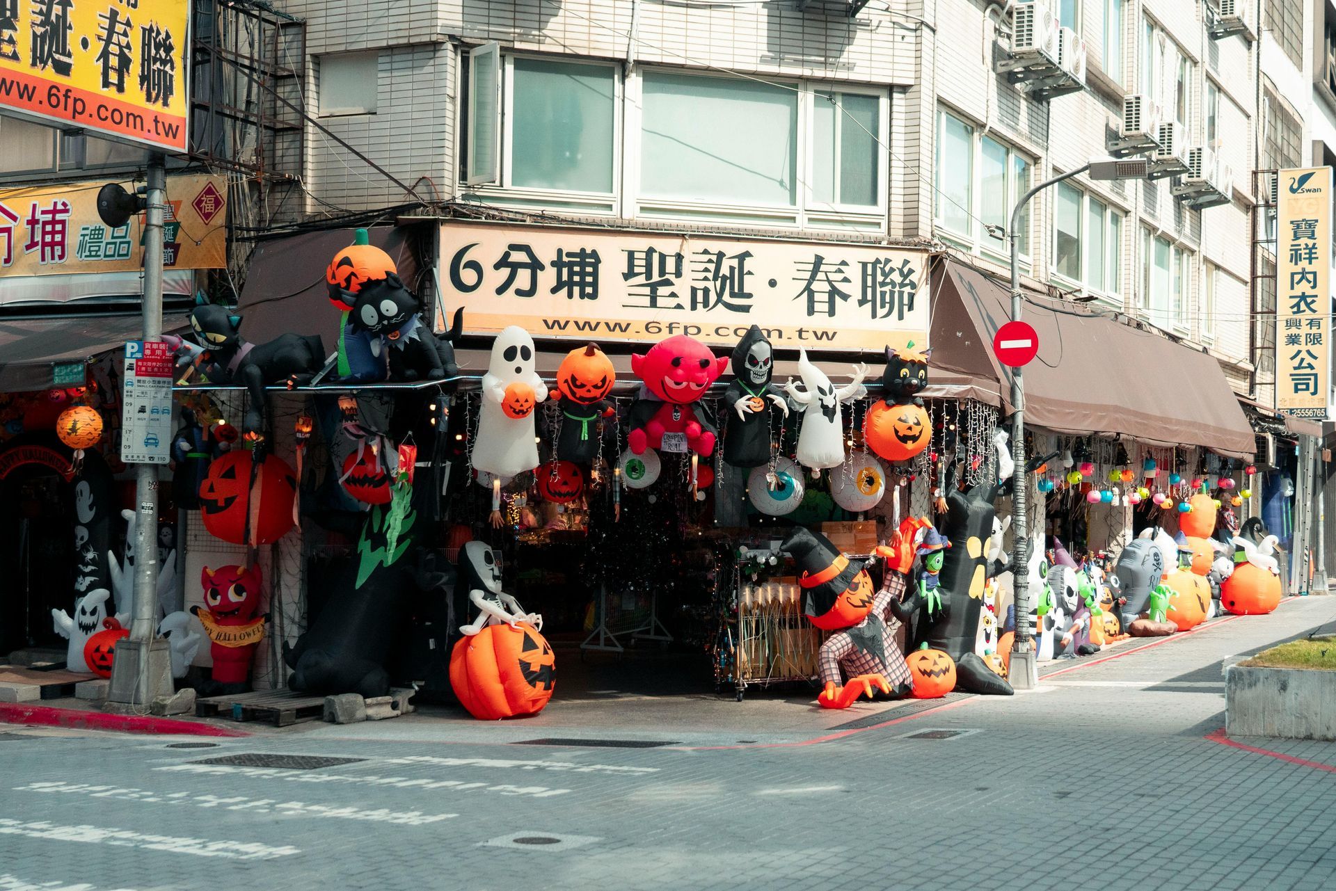 A storefront displaying Halloween decorations; orange pumpkins, ghosts, and other festive items. Taipei