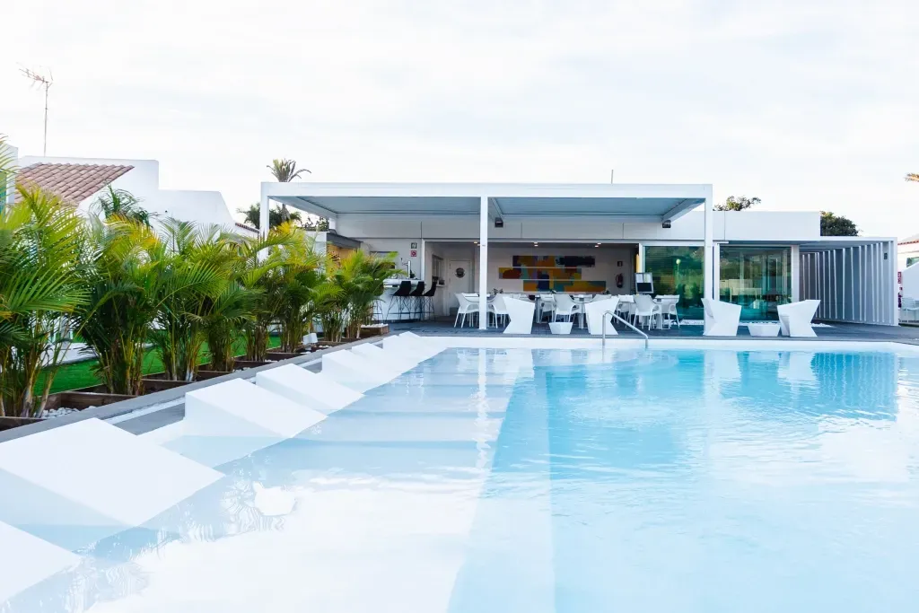 There is a large swimming pool in front of a house.