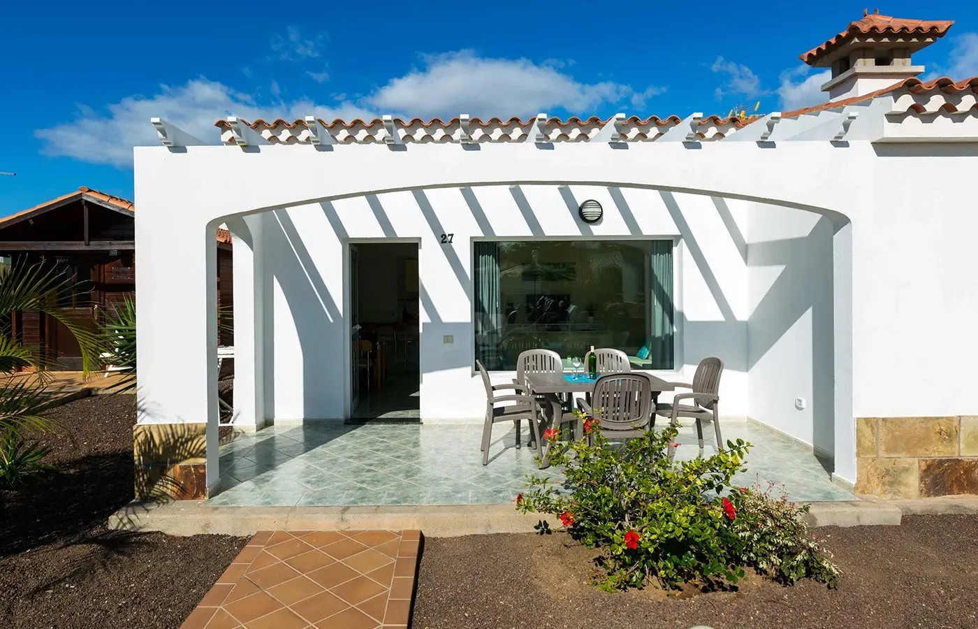 A white house with a patio with a table and chairs