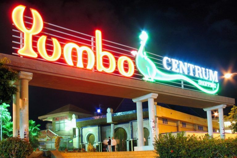 A neon sign for Yumbo centrum is lit up at night