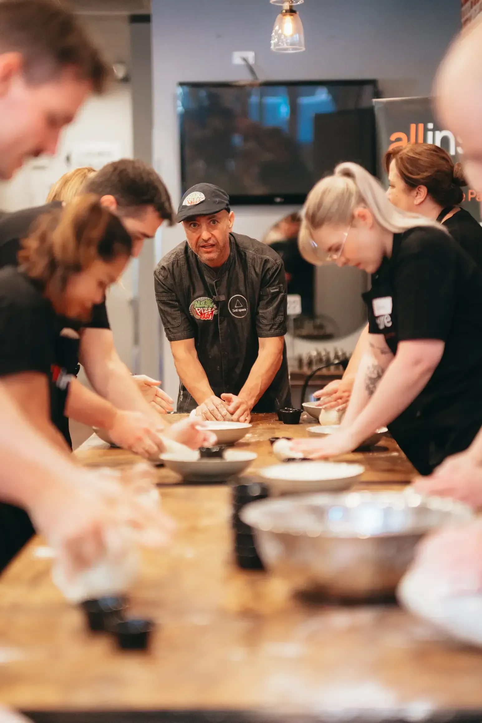 A group of people are standing around a table preparing food.