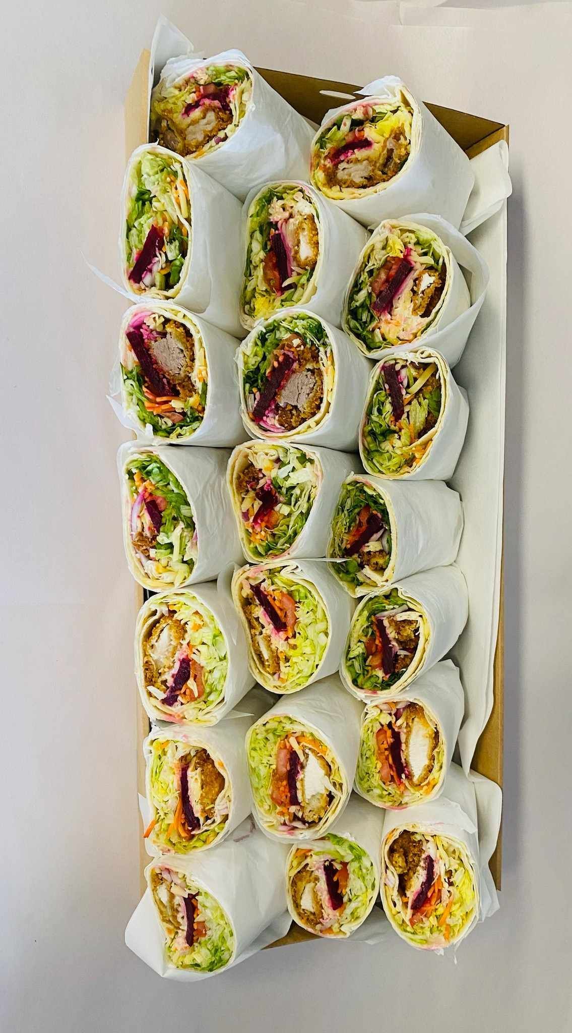 Box of wrapped sandwiches with visible fillings, greens, and sauce. — Boundary Street Fish & Burger Bar in Railway Estate, QLD