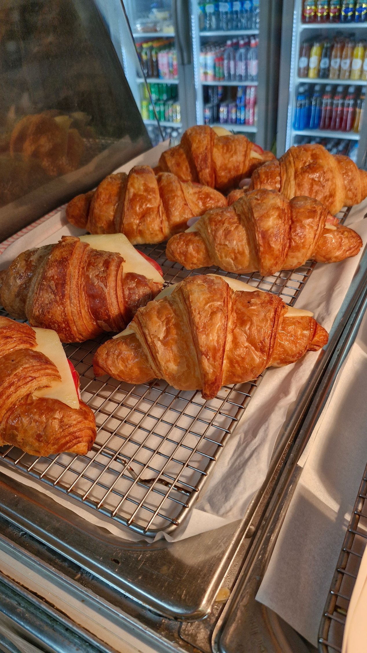 Croissants on a metal rack in a display case; drinks are visible in the background. — Boundary Street Fish & Burger Bar in Railway Estate, QLD