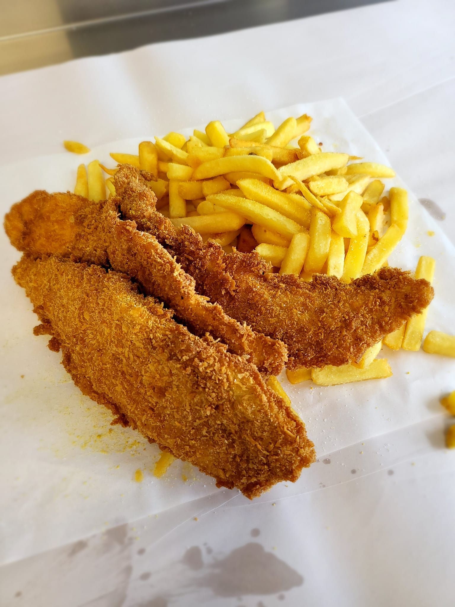 Fried Fish Fillets and French Fries on White Paper — Boundary Street Fish & Burger Bar in Railway Estate, QLD
